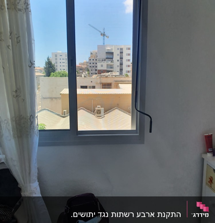 חלון אלומיניום עם נוף עירוני ברקע